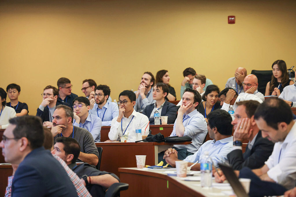 Spectators in an audience watch a lecture