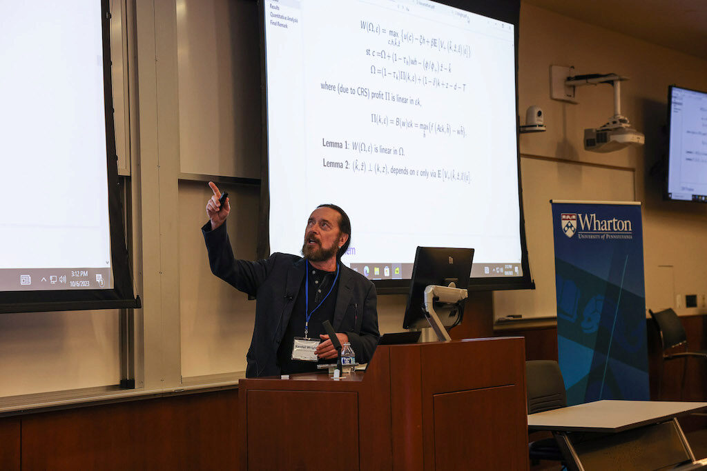 Randy Wright points up to a screen while lecturing