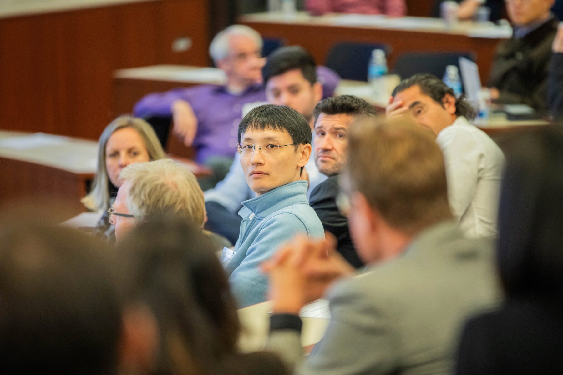 Audience members in a lecture hall speak to one another