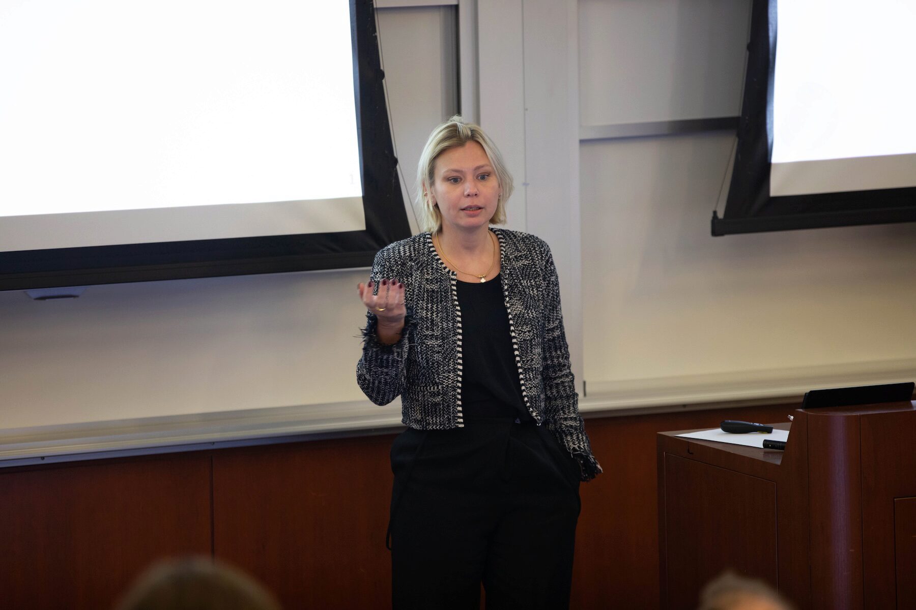 A speaker motions with her hands while presenting at a conference